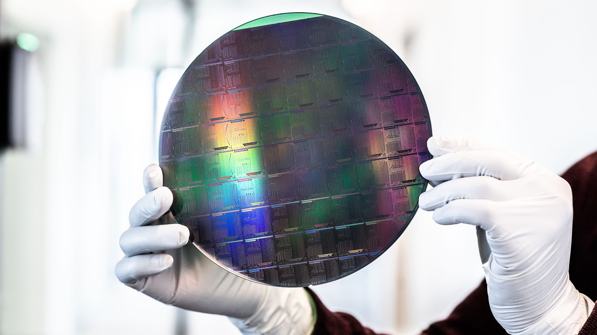 xanadu Gloved hands holding a colorful semiconductor wafer