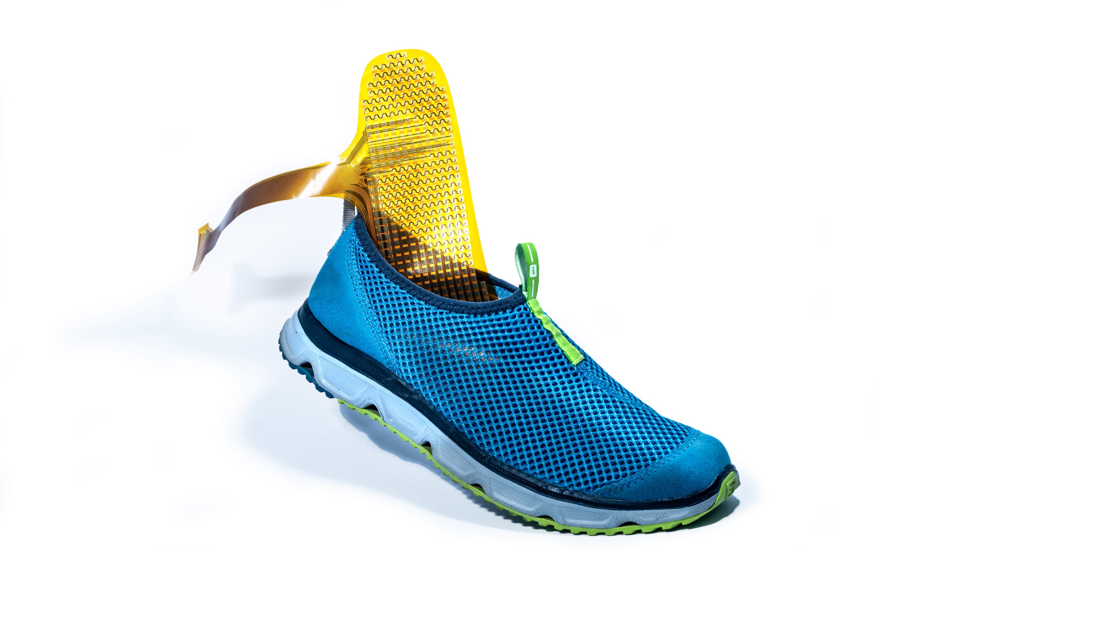 Blue athletic shoe with electronic insole sensor Blue athletic shoe with an electronic insole sensor and flexible ribbon connector on a white background.