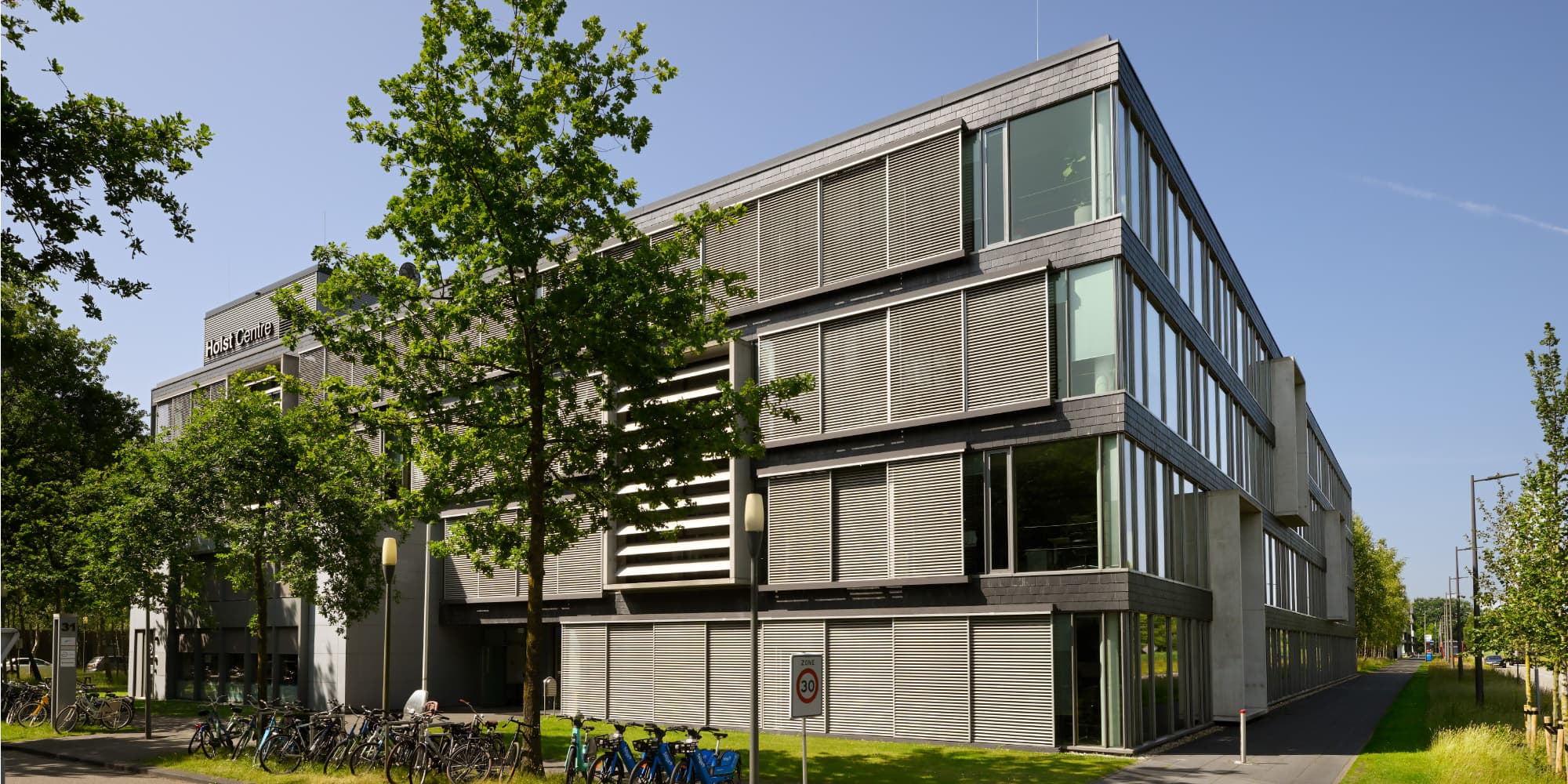 Holst-centre-2026 Holst Centre research building surrounded by trees on a sunny day