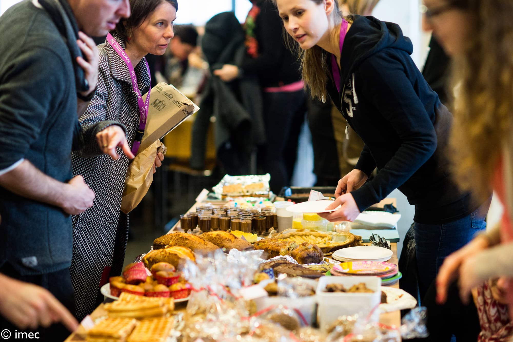 Levensloop People serving themselves at a buffet table during an imec gathering