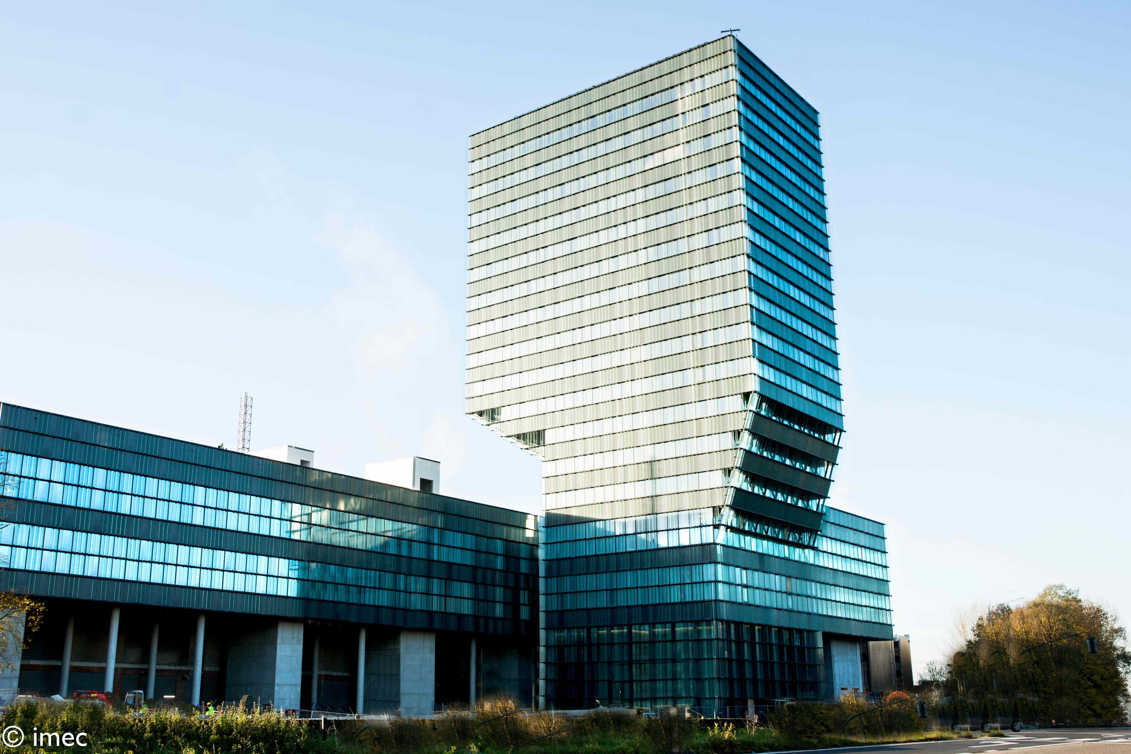 145-imec-tower-2022%20%281%29 imec headquarters building with a tall glass tower against a blue sky